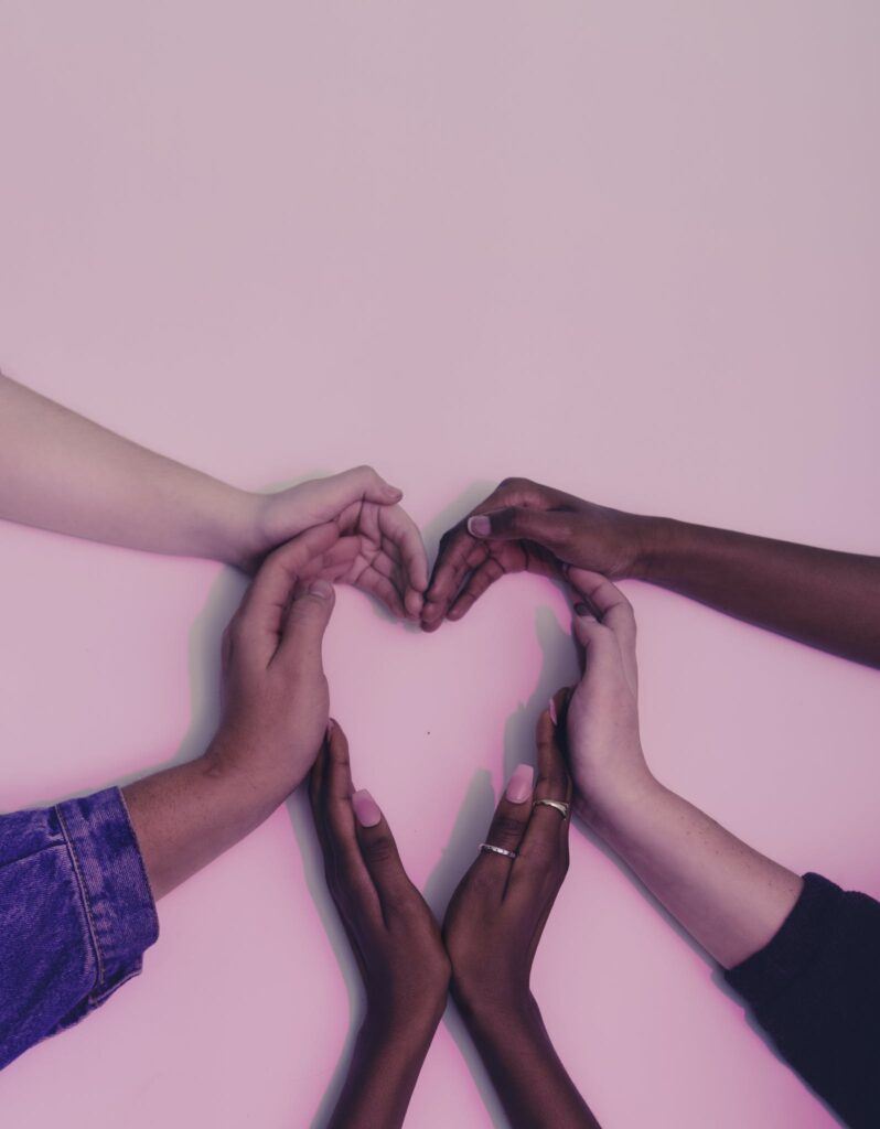 Human Hands Forming Heart on White Surface